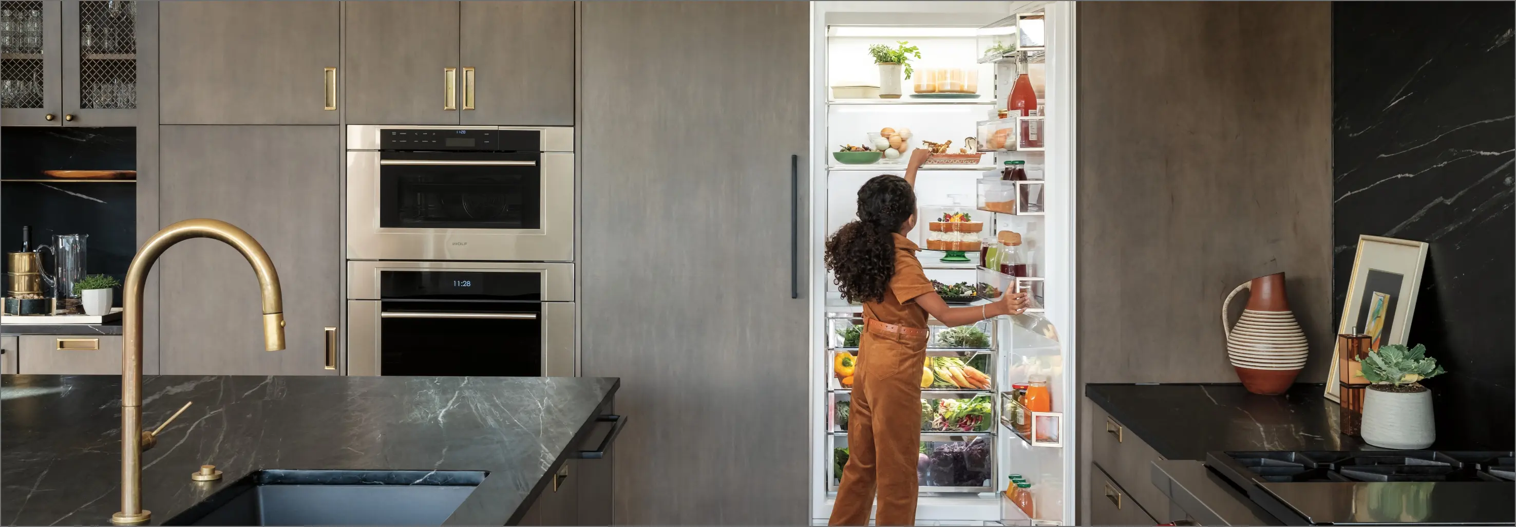 girl reaching into Sub-Zero's refrigerator