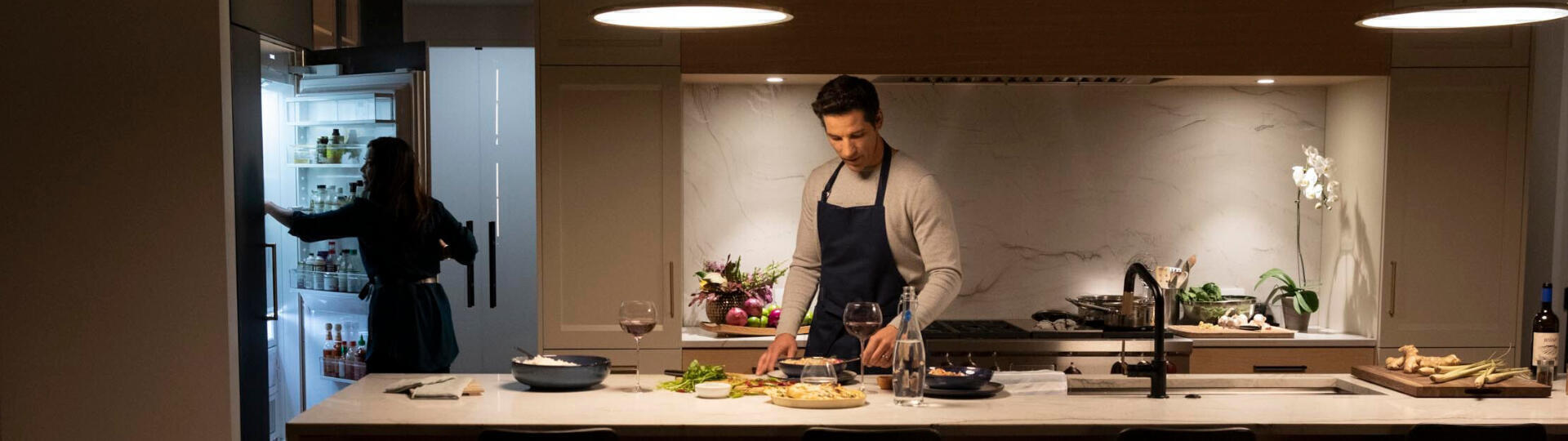 a couple preparing dinner with food preserved in Sub-Zero's refrigerator